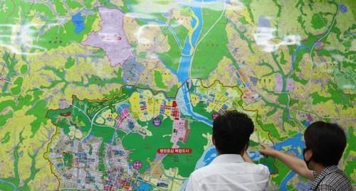 세종시의 한 부동산공인중개업소에서 아파트 매물을 문의하는 시민과 부동산 관계자가 지도를 보며 대화하고 있다.<연합뉴스>